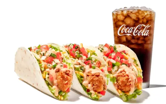 Three chicken finger tacos with lettuce, tomatoes, and cheese, served with a drink