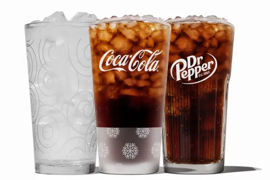 Three glasses of iced cola drinks including Coca-Cola and Dr Pepper