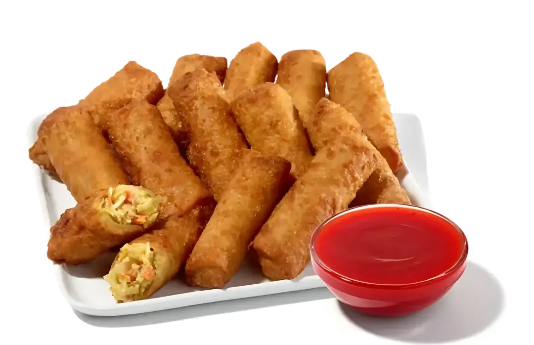 Vegetable egg roll platter with crispy rolls, dipping sauce, and assorted sides on serving plate.
