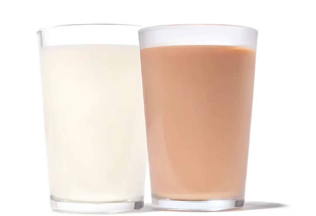 Two glasses of milk: one white (plain milk) and one light brown (chocolate milk), side by side.
