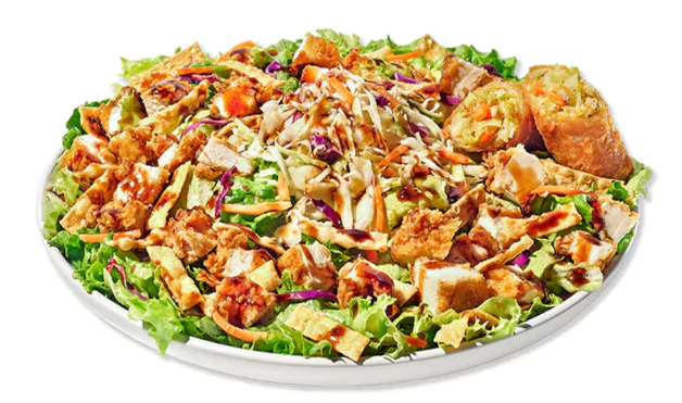 Crispy chicken salad with mixed greens, cheese, vegetables, and creamy dressing